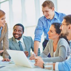 Group of employees looking at confident manager explaining her ideas at meeting