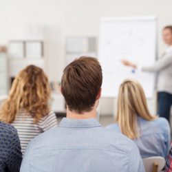 frau hält einen vortrag am flipchart vor einer gruppe