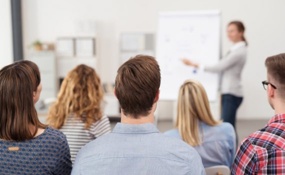 frau hält einen vortrag am flipchart vor einer gruppe